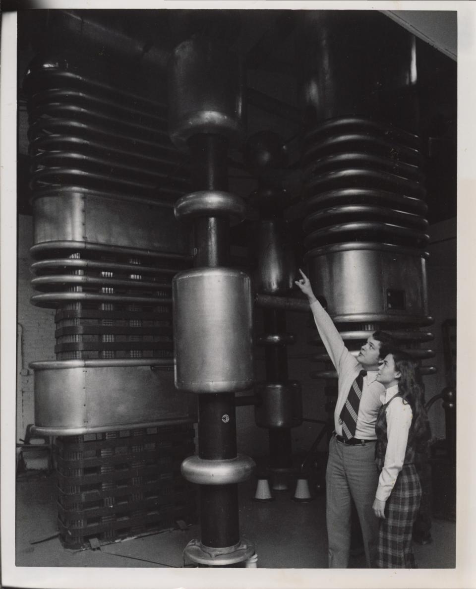 Physics department Chair Dr. William Sawyer and student Rebecca Krampitz observing the Allison particle accelerator at Elmhurst College, 1977.